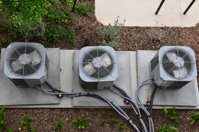 3 outdoor HVAC units with cleaned space around them
