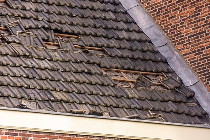 Tile roof that is falling apart due to wind damage